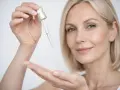Kobieta aplikuje serum z pipetki. Pamiętaj, z czym nie łączyć niacynamidu, by uniknąć podrażnień.