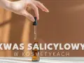 Dłoń trzyma pipetkę z serum. Tekst informuje z czym nie łączyć kwasu salicylowego w kosmetykach.