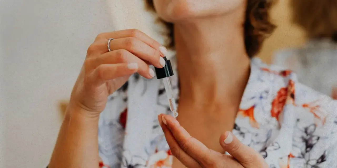 Kobieta aplikuje serum z pipetki na dłoń. Czy peptydy są bezpieczne? To pytanie nurtuje wiele osób dbających o cerę.