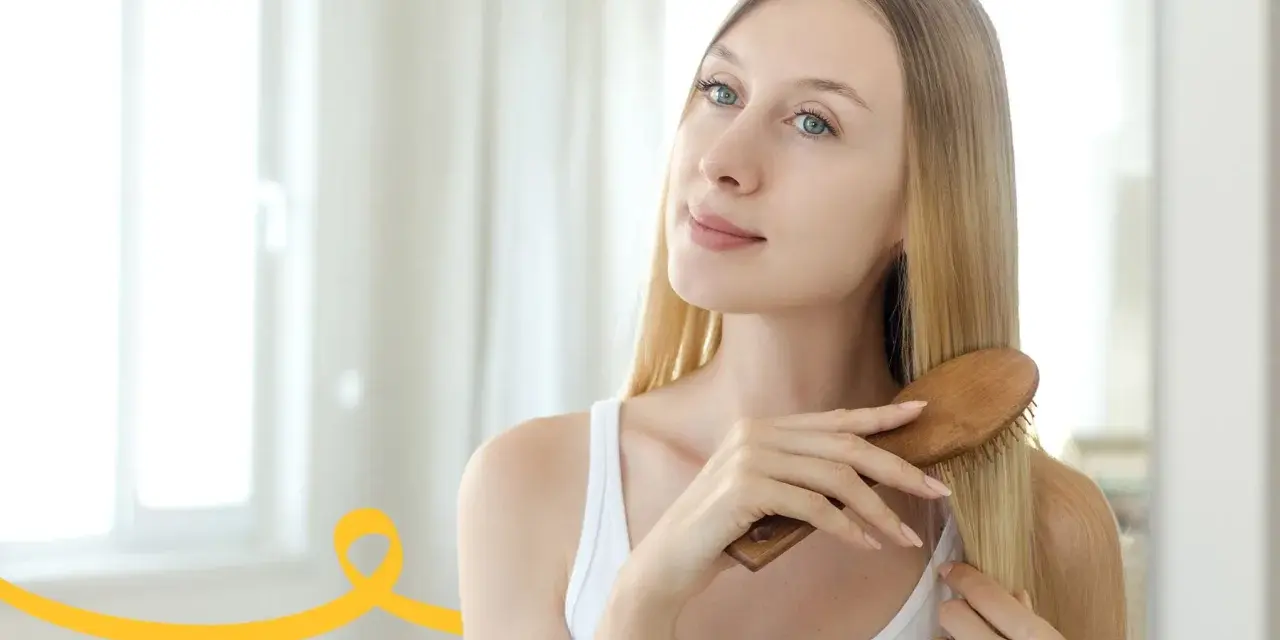 Kobieta szczotkuje włosy, wykonując domowy peeling skóry głowy.