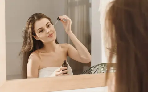 Kwas azelainowy z czym łączyć? Młoda kobieta aplikuje serum z pipetką, by uzyskać gładką cerę.